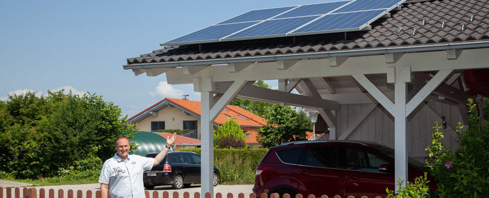 Herr Vietze vor seinem Carport mit PV