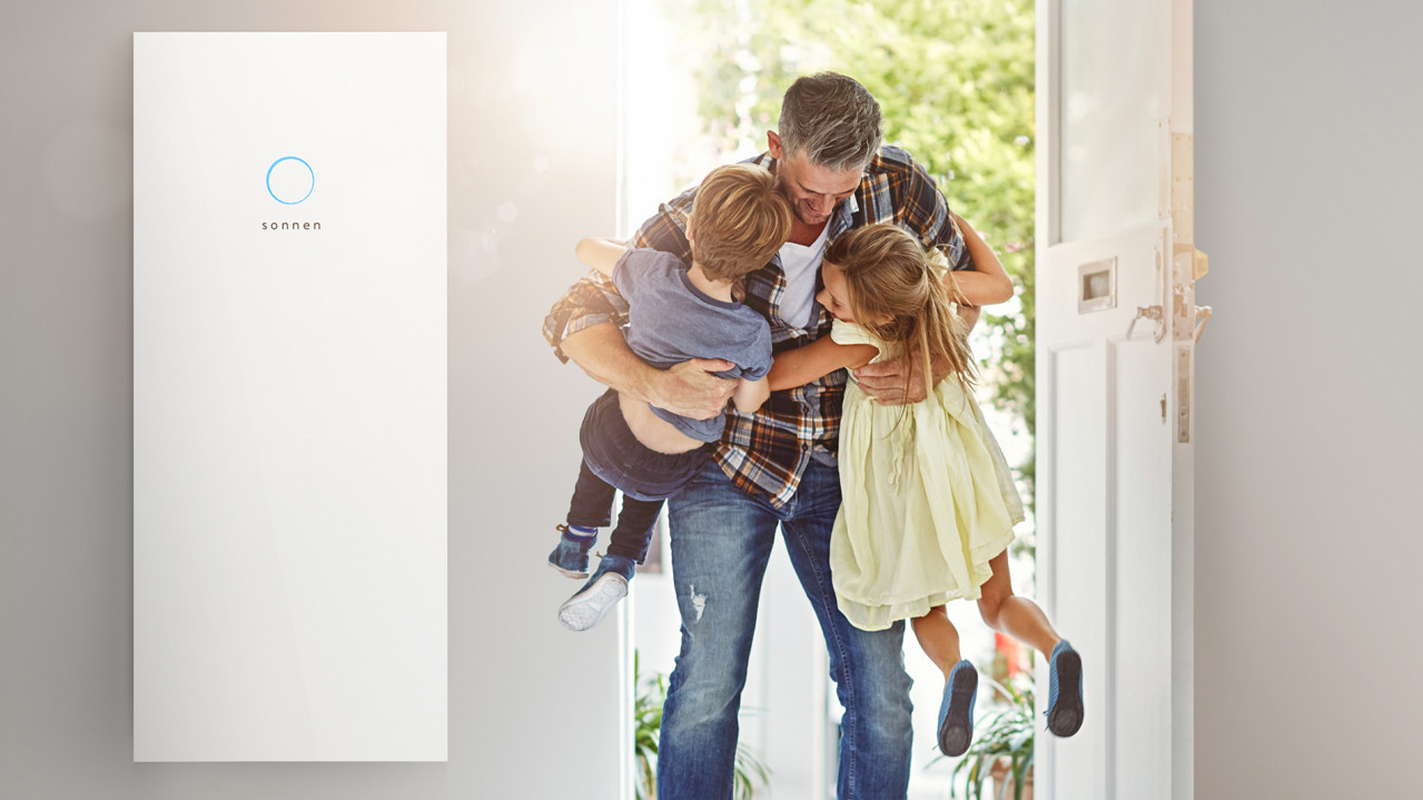 A father greets his children in the hallway with a sonnenBatterie