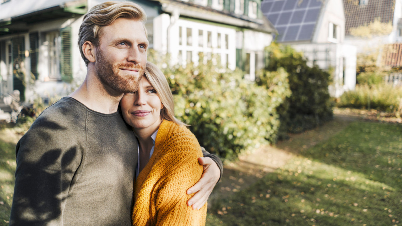 A couple in front of their solar-powered house