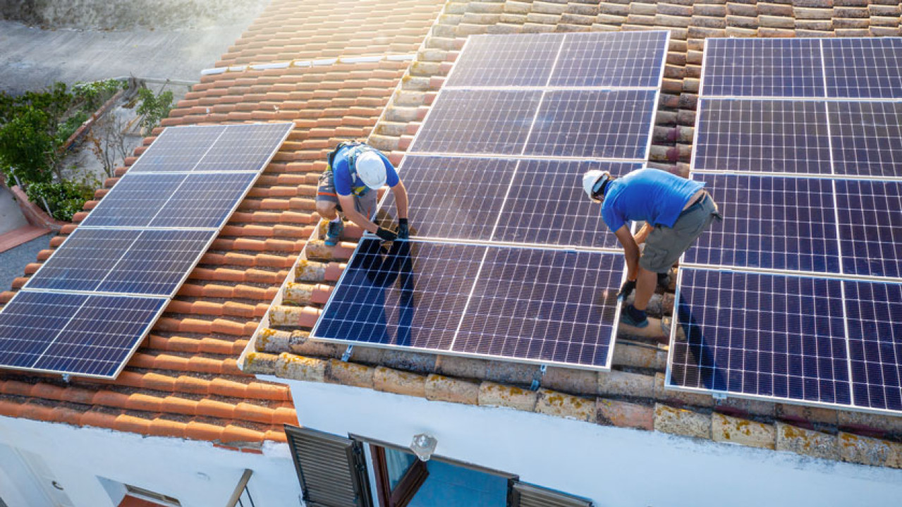 two workers install solar panels