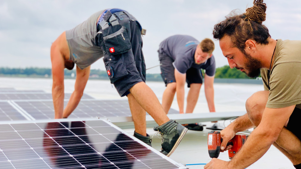 Mitarbeitende Elektro Segeth auf dem Dach bei der PV-Installation.