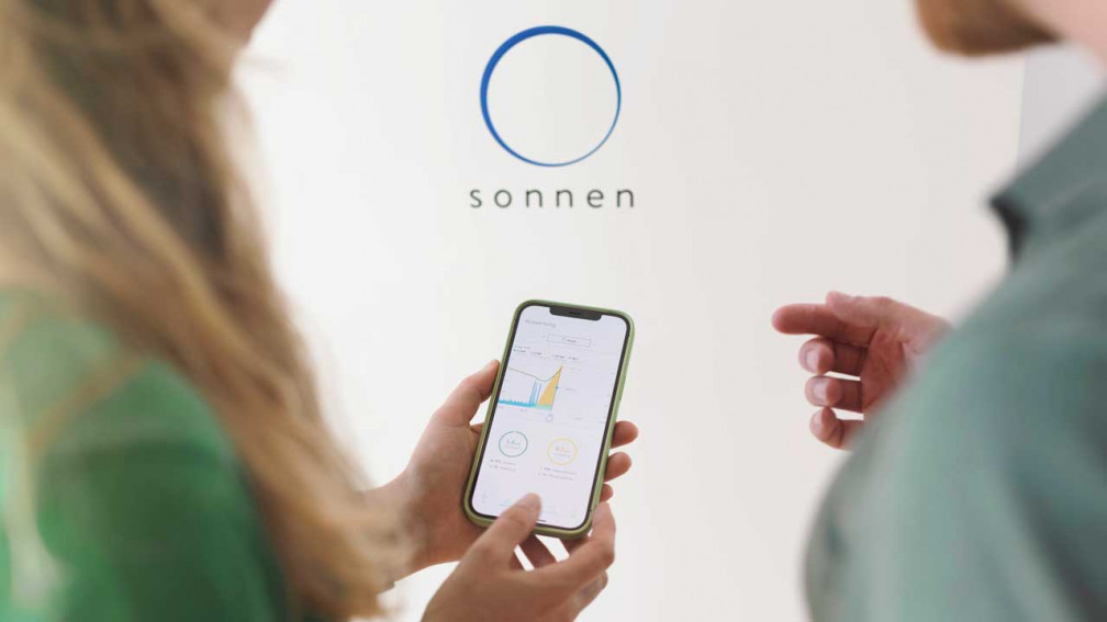 Smartphone mit sonnen App vor der sonnenBatterie 