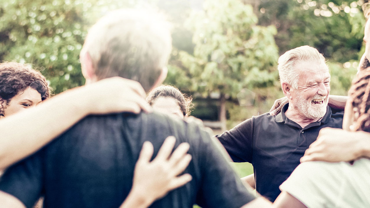 A group of people in a circle hugging each other